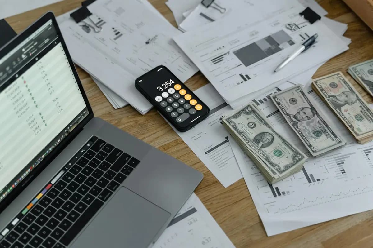 Calculadora y billetes de euro sobre una mesa para calcular ayudas y deducciones del cuidador